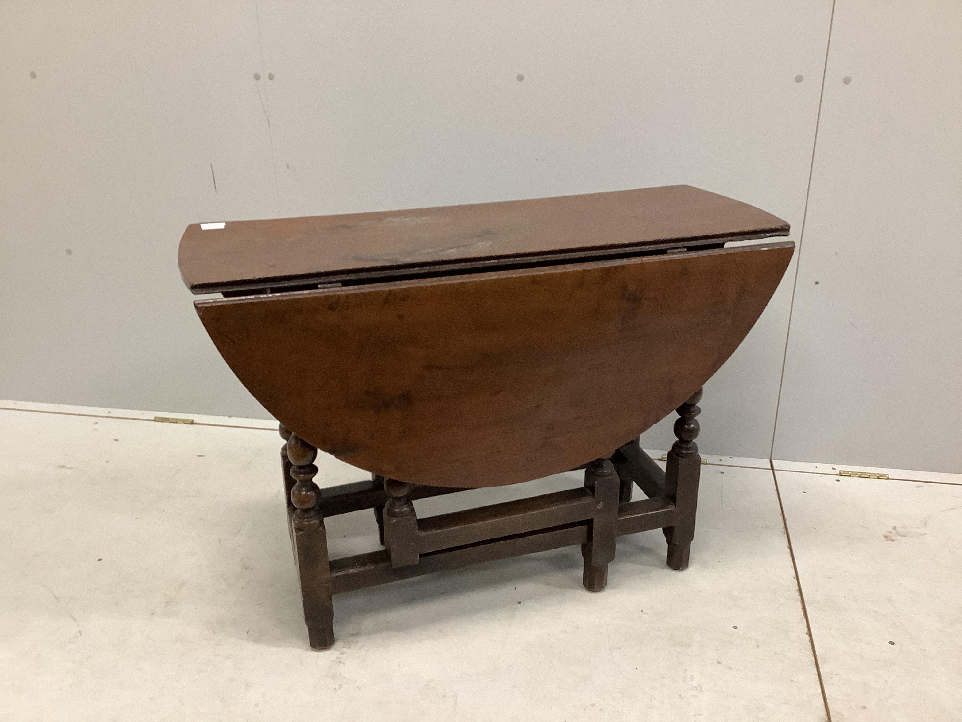 An 18th century oak gateleg table with an oval top on baluster turned under frame, 112cm extended, depth 100cm, height 68cm. Condition - fair